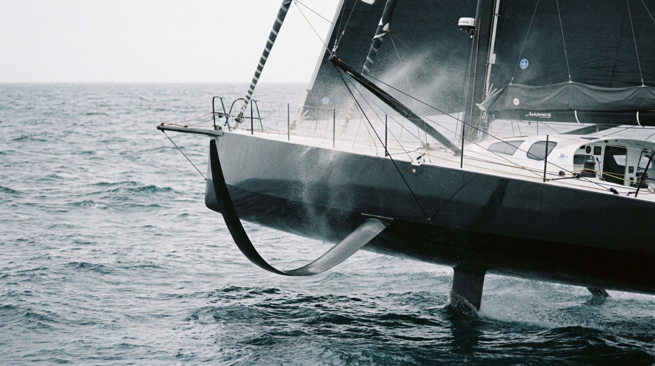 Foil kanatlarıyla deniz yüzeyini süzen IMOCA 60 offshore yarış teknesi
