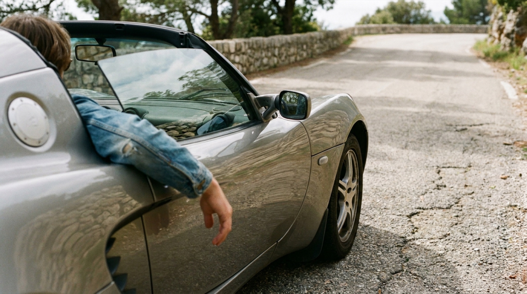 Lotus Elise dar bir kıvrımda asfalt üzerinde yalın şasi görünümüyle, ön tekerlekler hafifçe steere